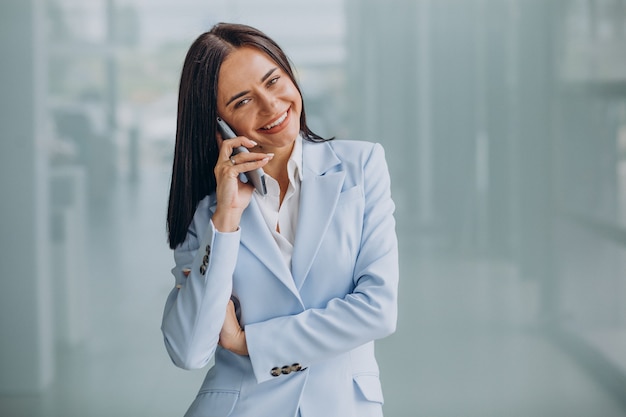 Mujer de negocios joven mediante teléfono móvil