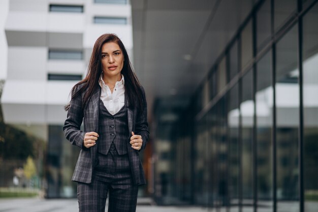 Mujer de negocios joven en traje elegante por centro de oficina