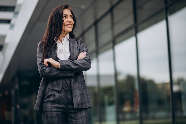 Foto gratuita mujer de negocios joven en traje elegante por centro de oficina