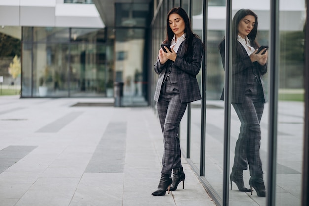 Mujer de negocios joven en traje elegante por centro de oficina