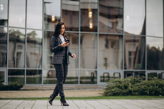 Mujer de negocios joven en traje elegante por centro de oficina