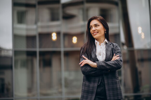 Mujer de negocios joven en traje elegante por centro de oficina