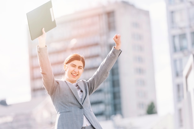 Foto gratuita mujer de negocios levantando brazos al aire libre