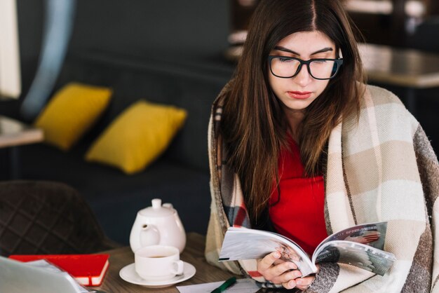 Mujer de negocios leyendo en cafetería