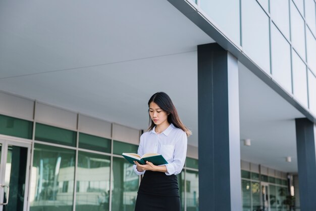 Mujer de negocios leyendo fuera