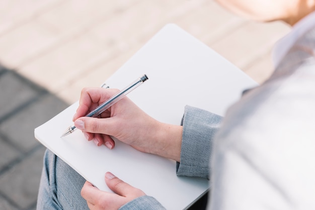 Mujer de negocios con libro abierto al aire libre