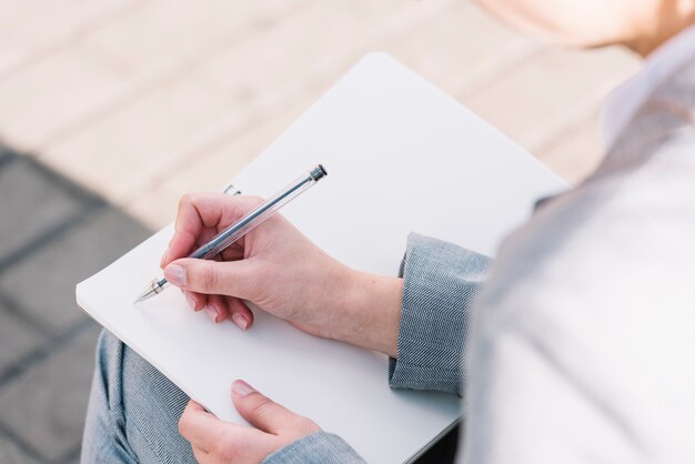 Mujer de negocios con libro abierto al aire libre