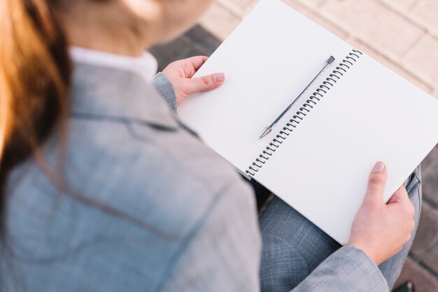 Mujer de negocios con libro abierto al aire libre