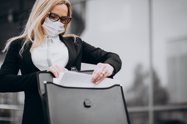 Mujer de negocios con máscara fuera del centro de negocios