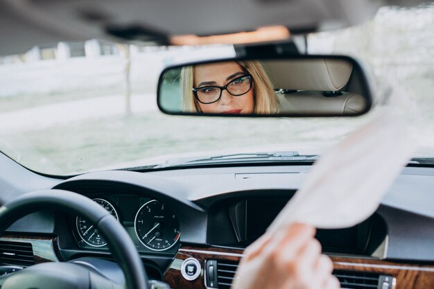 Mujer de negocios con máscara de protección sentado dentro de un automóvil