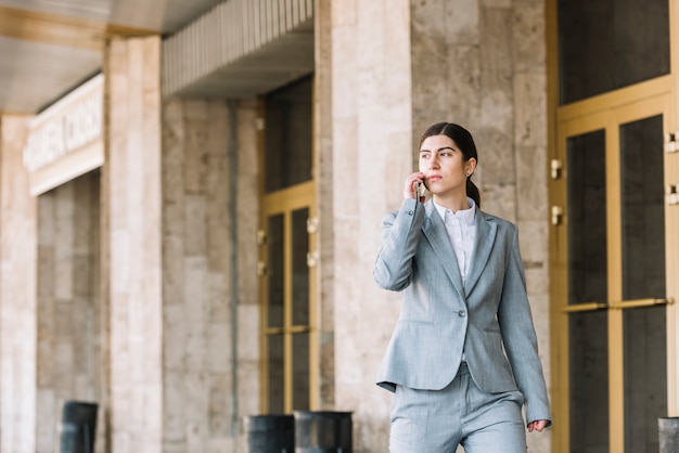 Mujer de negocios moderna haciendo llamada al aire libre