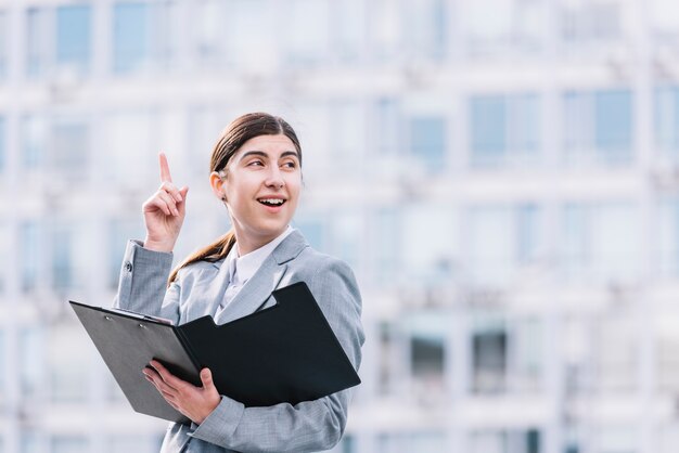 Mujer de negocios moderna con portapapeles al aire libre