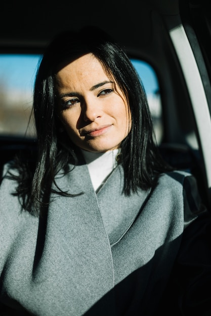 Mujer de negocios moderna sentada en coche