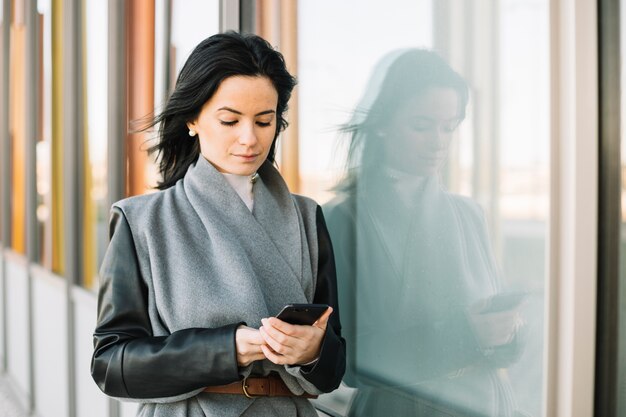 Mujer de negocios moderna usando smartphone al aire libre