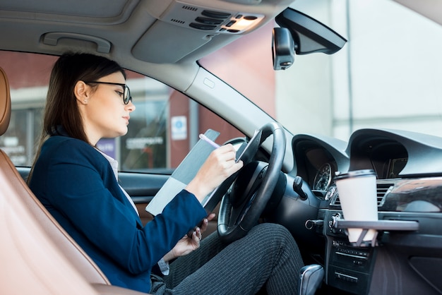 Mujer de negocios morena dentro de un coche