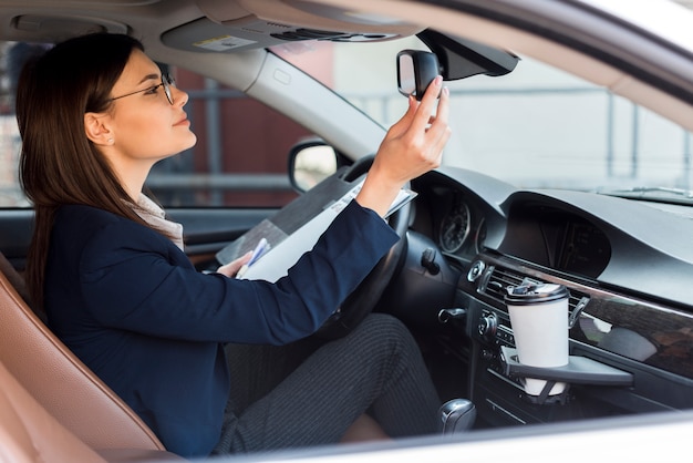 Mujer de negocios morena dentro de un coche