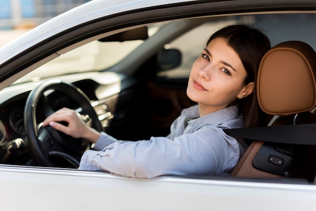 Foto gratuita mujer de negocios morena dentro de un coche