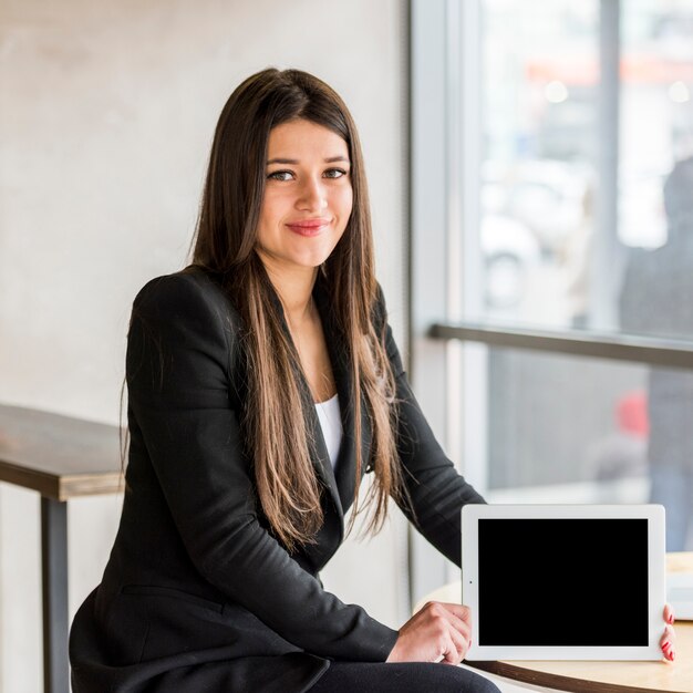 Mujer de negocios morena enseñando su tablet