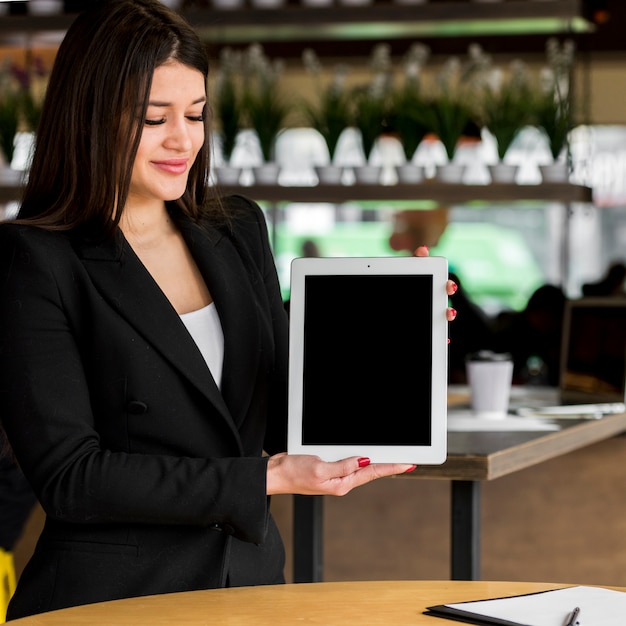 Mujer de negocios morena enseñando tablet