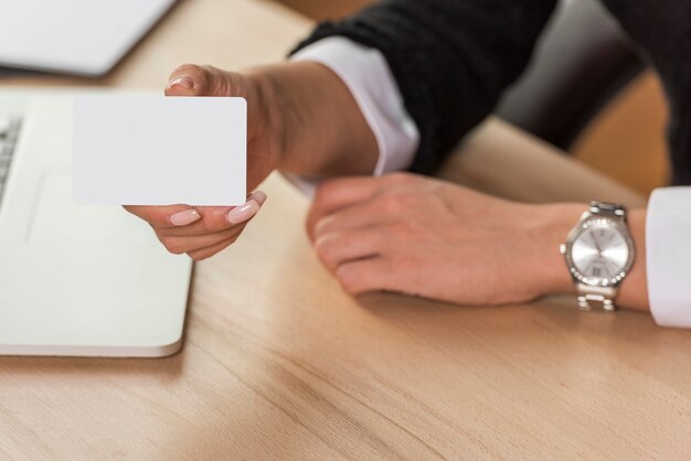 Mujer de negocios morena  enseñando tarjeta vacía