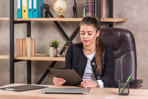 Mujer de negocios morena  leyendo documento