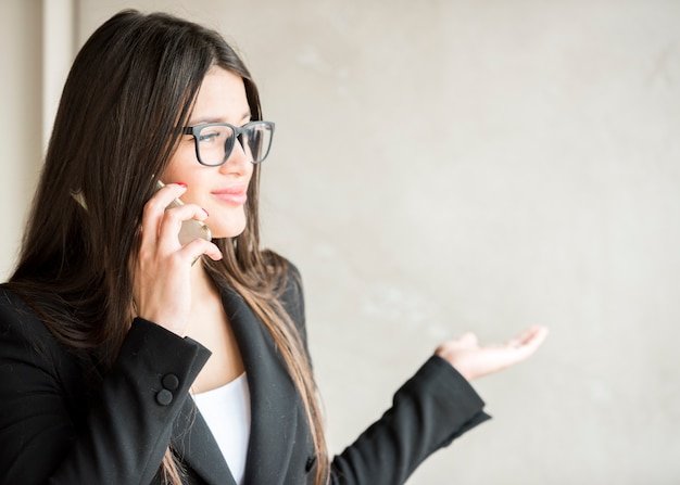 Mujer de negocios morena llamando por móvil