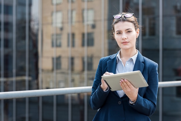 Mujer de negocios morena posando con una tablet