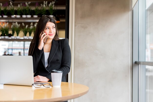 Mujer de negocios morena usando su smartphone