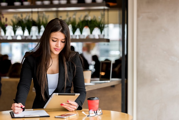 Mujer de negocios morena usando su tablet