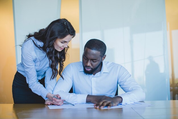 Mujer de negocios mostrando algo a un hombre