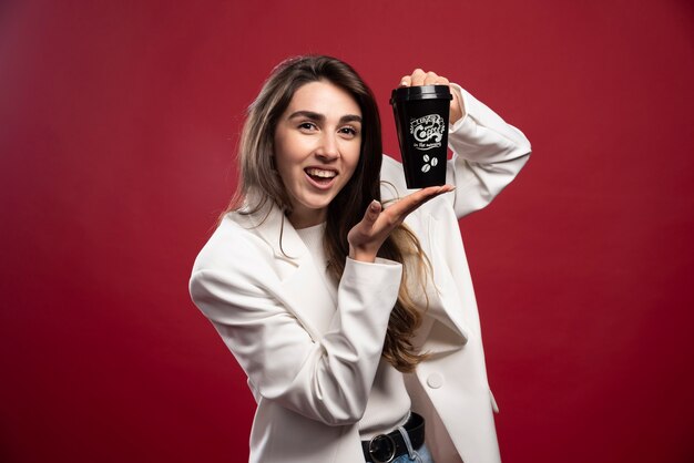 Mujer de negocios mostrando una taza de café