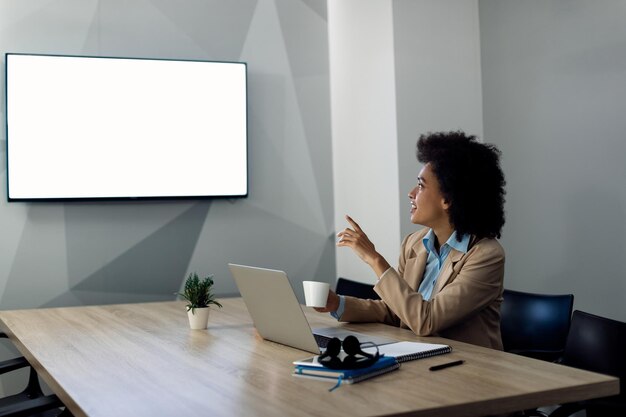 Mujer de negocios negra con llamada de conferencia en la oficina