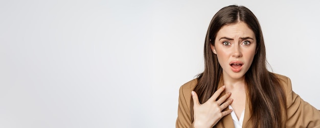 Foto gratuita mujer de negocios ofendida sorprendida señalándose a sí misma luciendo insultada y herida discutiendo de nuevo