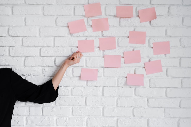 Foto gratuito mujer de negocios pegando notas adhesivas en la pared
