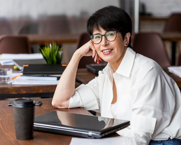 Mujer de negocios de pelo corto con gafas de lectura