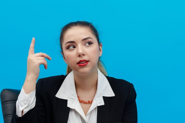 Mujer de negocios pensativa levantando el dedo y pensando