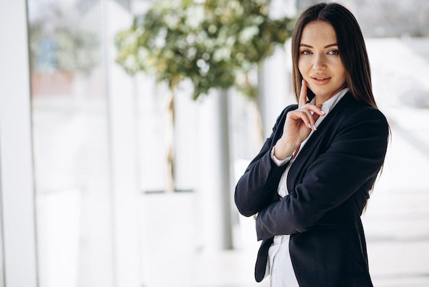 Foto gratuita mujer de negocios de pie en la oficina con ropa formal