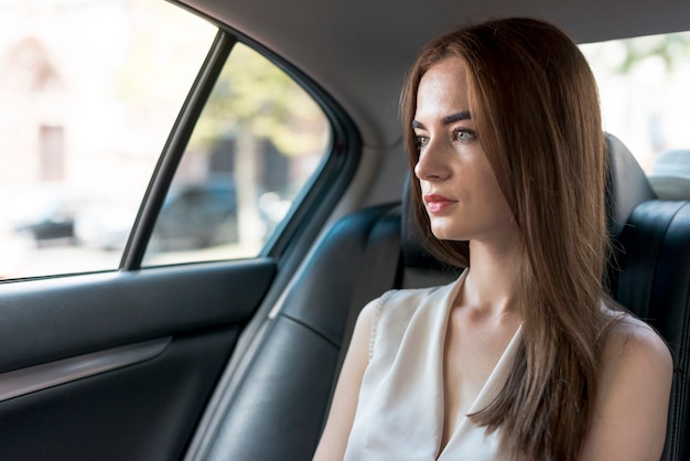 Mujer de negocios posando dentro de un coche