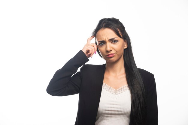 Mujer de negocios, posar, en, pared blanca