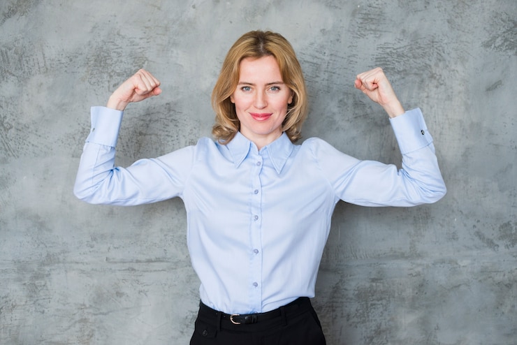 Foto gratuito mujer de negocios que muestra los músculos del brazo