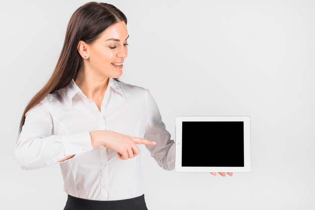 Mujer de negocios que señala el dedo en la tableta con pantalla en blanco