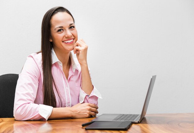 Mujer de negocios que sonríe con el fondo blanco