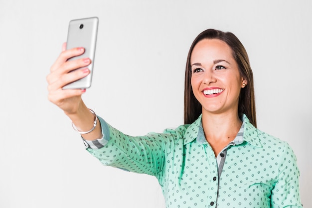 Foto gratuita mujer de negocios que toma un selfie en la oficina