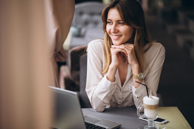 Mujer de negocios que trabaja en la computadora en un café