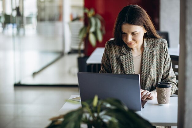 Mujer de negocios que trabaja en la computadora portátil en la oficina