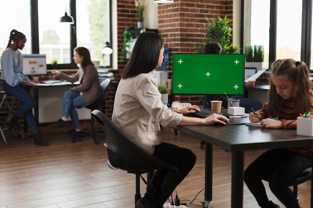 Mujer de negocios que trabaja usando una computadora con una plantilla de clave de croma en blanco. Empleado de la empresa mirando la pantalla con fondo en blanco, plantilla aislada y espacio de copia de clave de croma en el monitor.