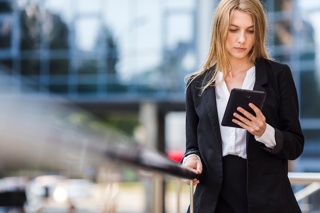 Mujer de negocios que usa una tableta al aire libre