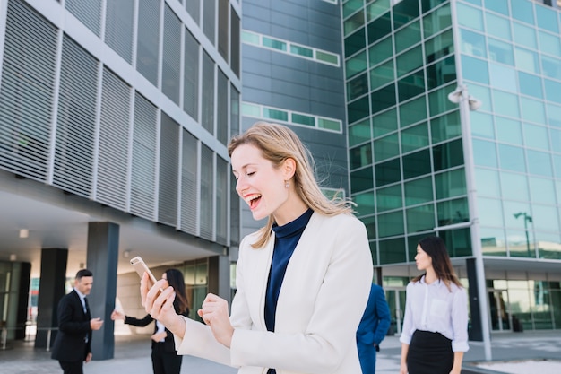 Foto gratuita mujer de negocios recibiendo noticias buenas en smartphone