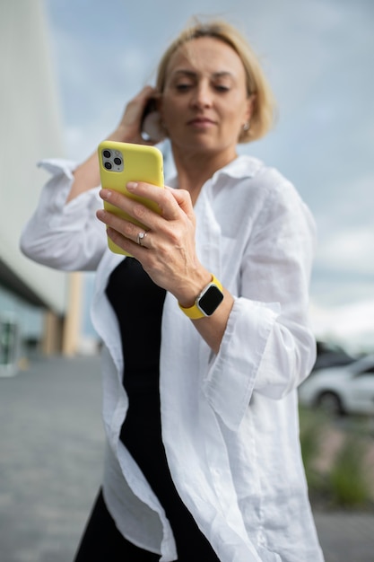 Mujer de negocios rubia comprobando su teléfono