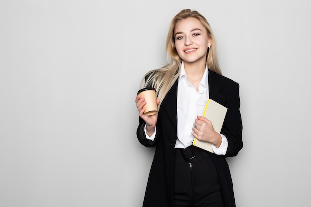 Mujer de negocios rubia escribiendo en su cuaderno aislado